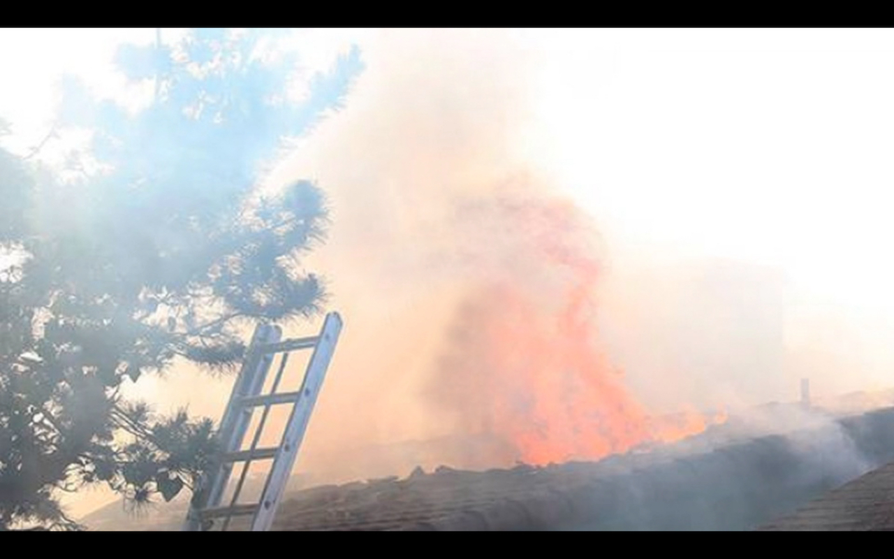 Fire coming out hole in roof during Atascadero Street Fire in San Luis Obispo California in 2016.